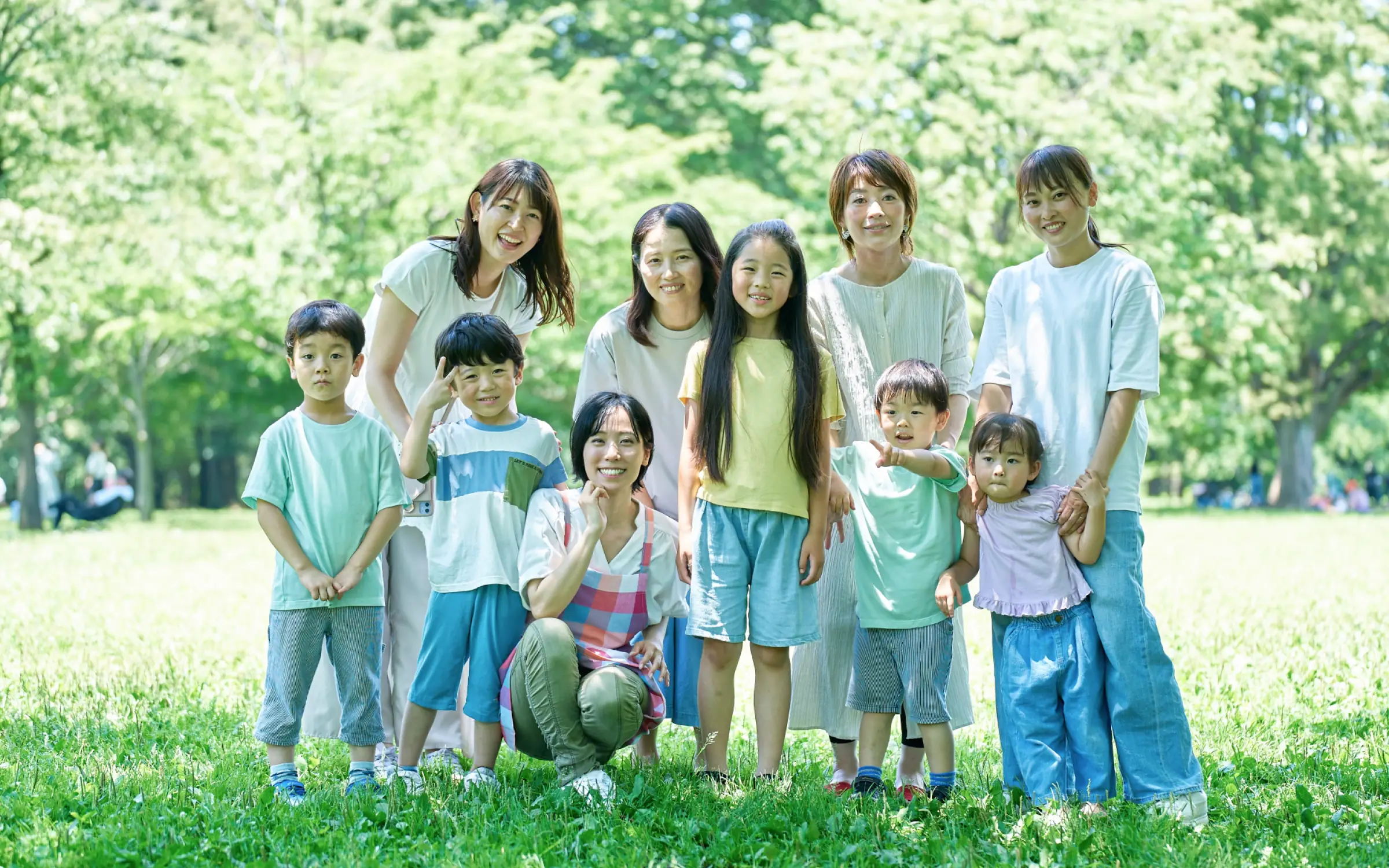 芝生の上に並んで笑顔のこどもたちとスタッフ